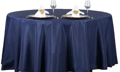 Navy blue round table set for dining, with place settings.