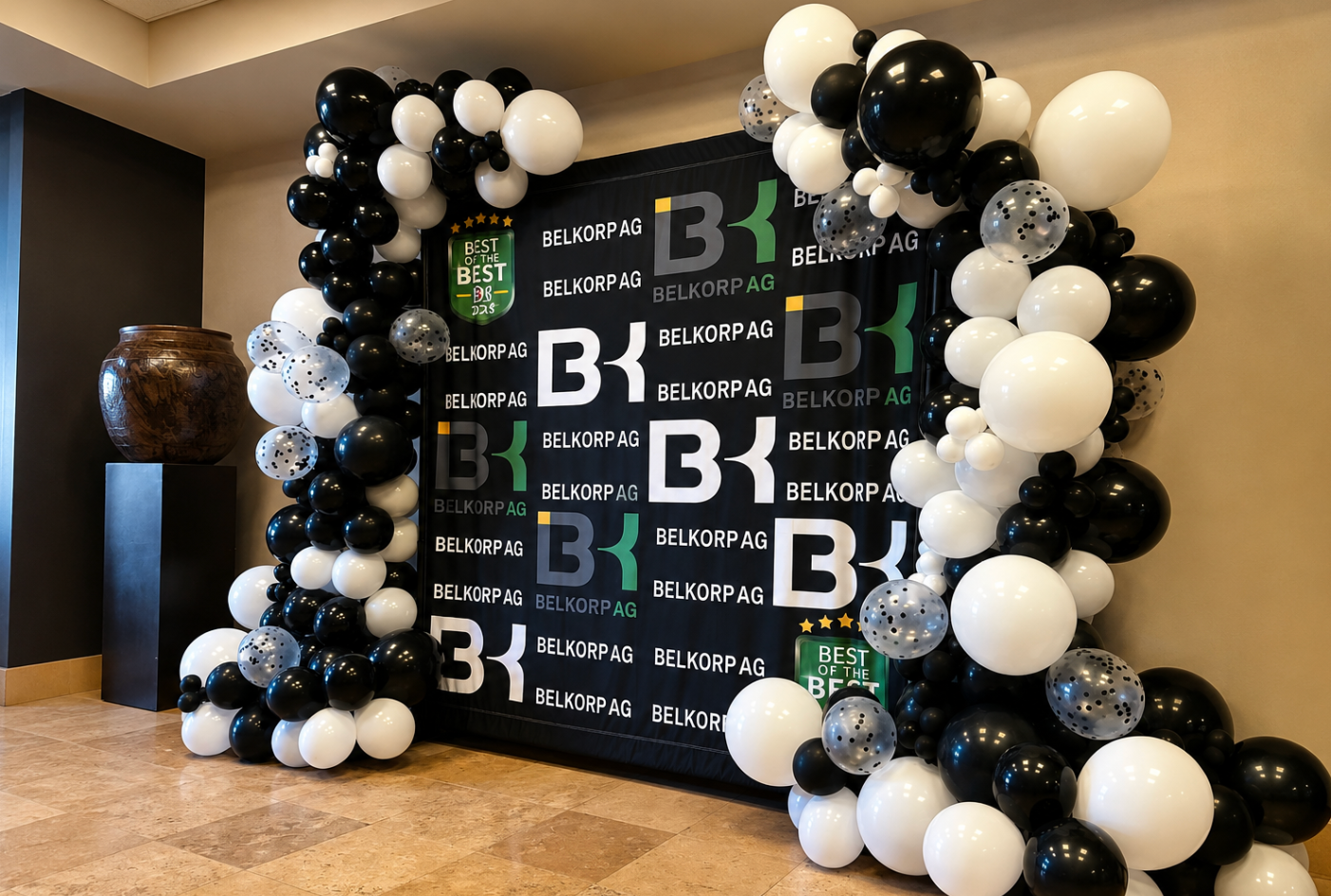Black and white organic balloon garland framing a custom corporate event backdrop.