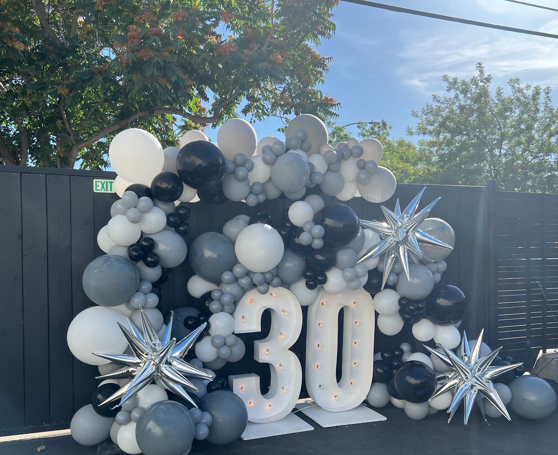 30th birthday display with black, white, and gray balloons, light-up