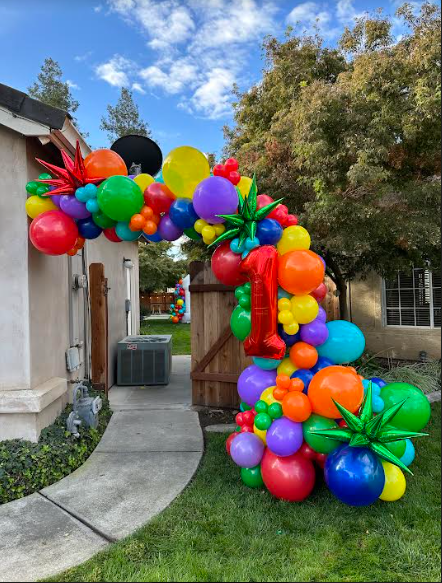 Colorful balloon archway for a first birthday. Includes