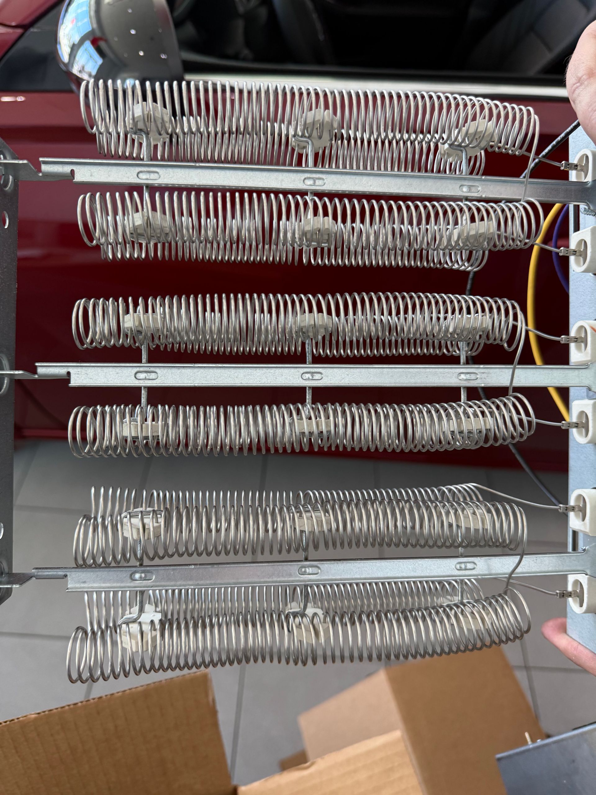 Stacked metal coiled springs on a rack in a workshop, with cardboard boxes below
