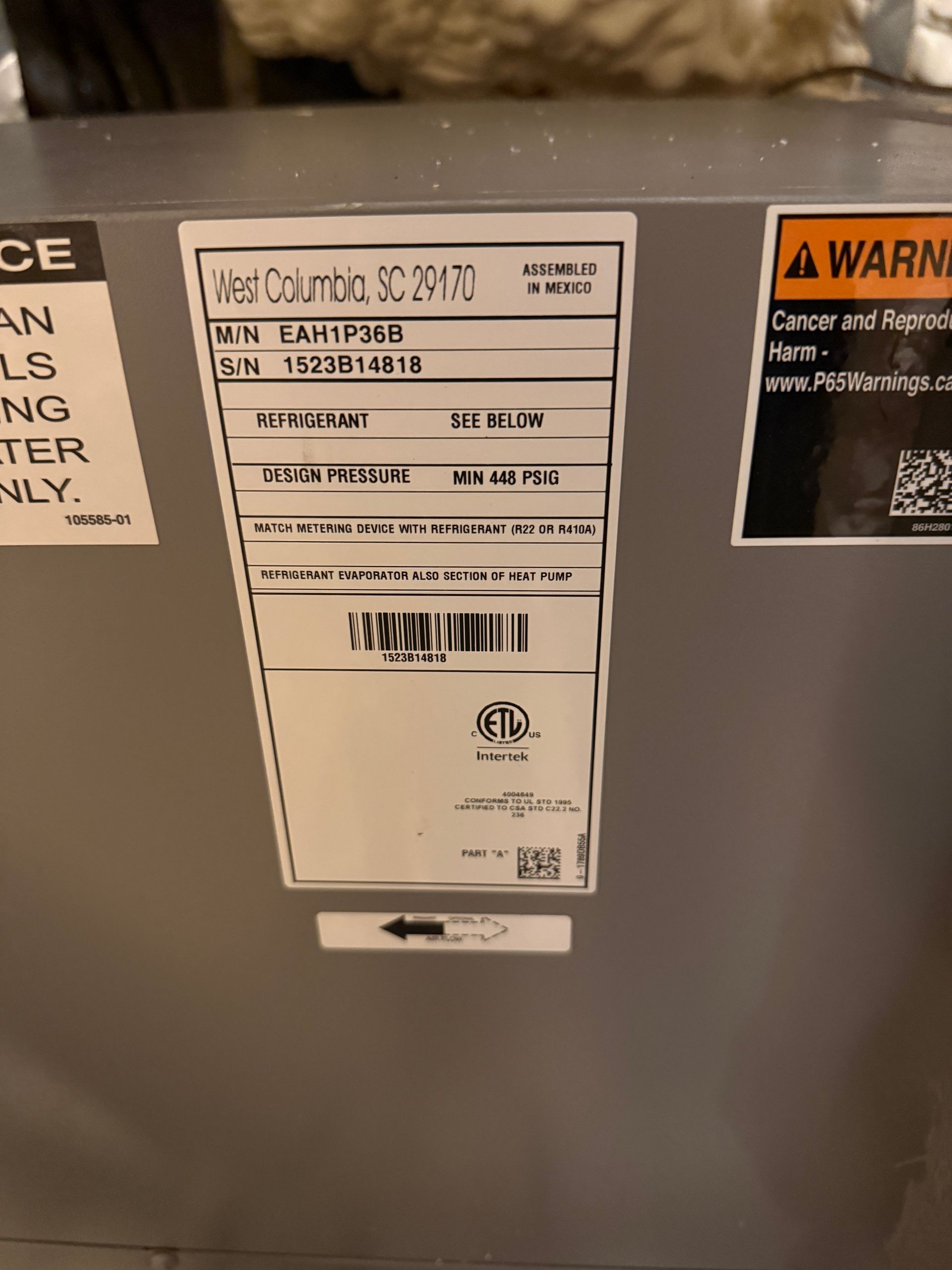 Close-up of a gray appliance control label with warning stickers on the door.