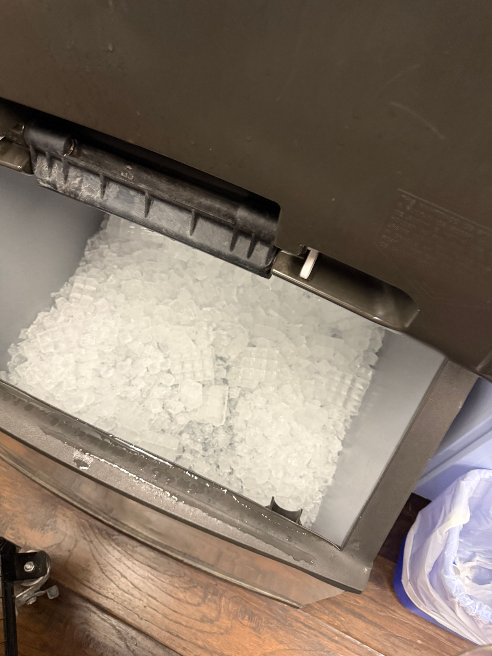 Ice filling a tray inside a chest-style ice maker.