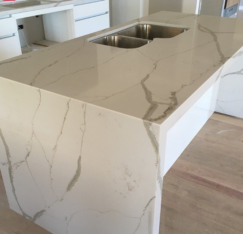 A kitchen with a marble counter top and a sink