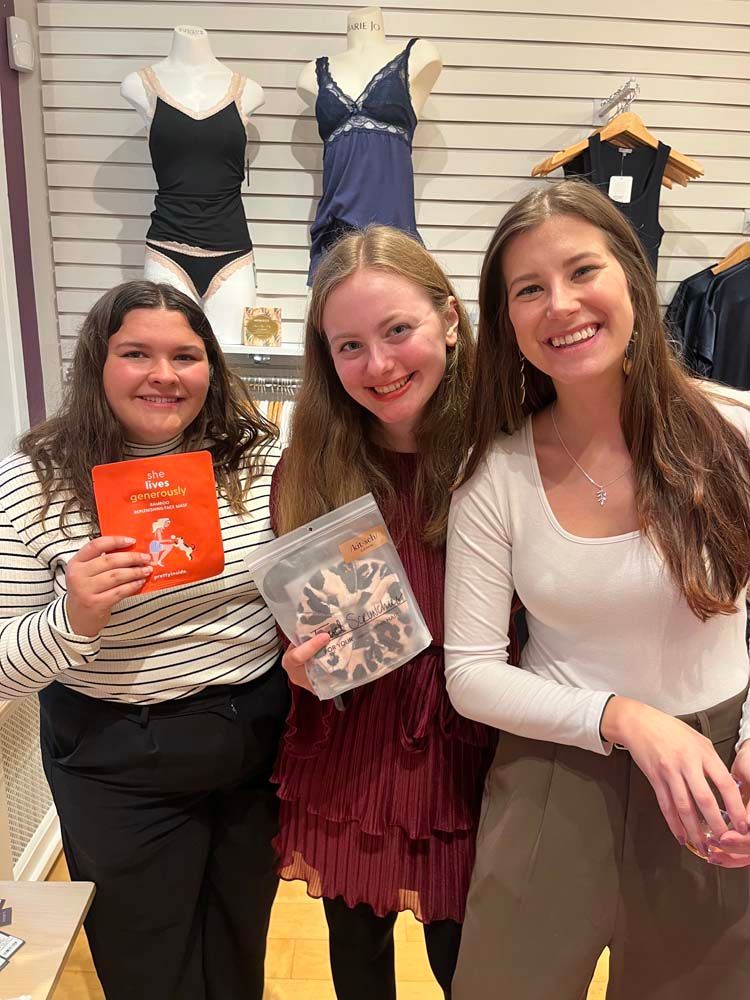 Three young women are posing for a picture in a store.