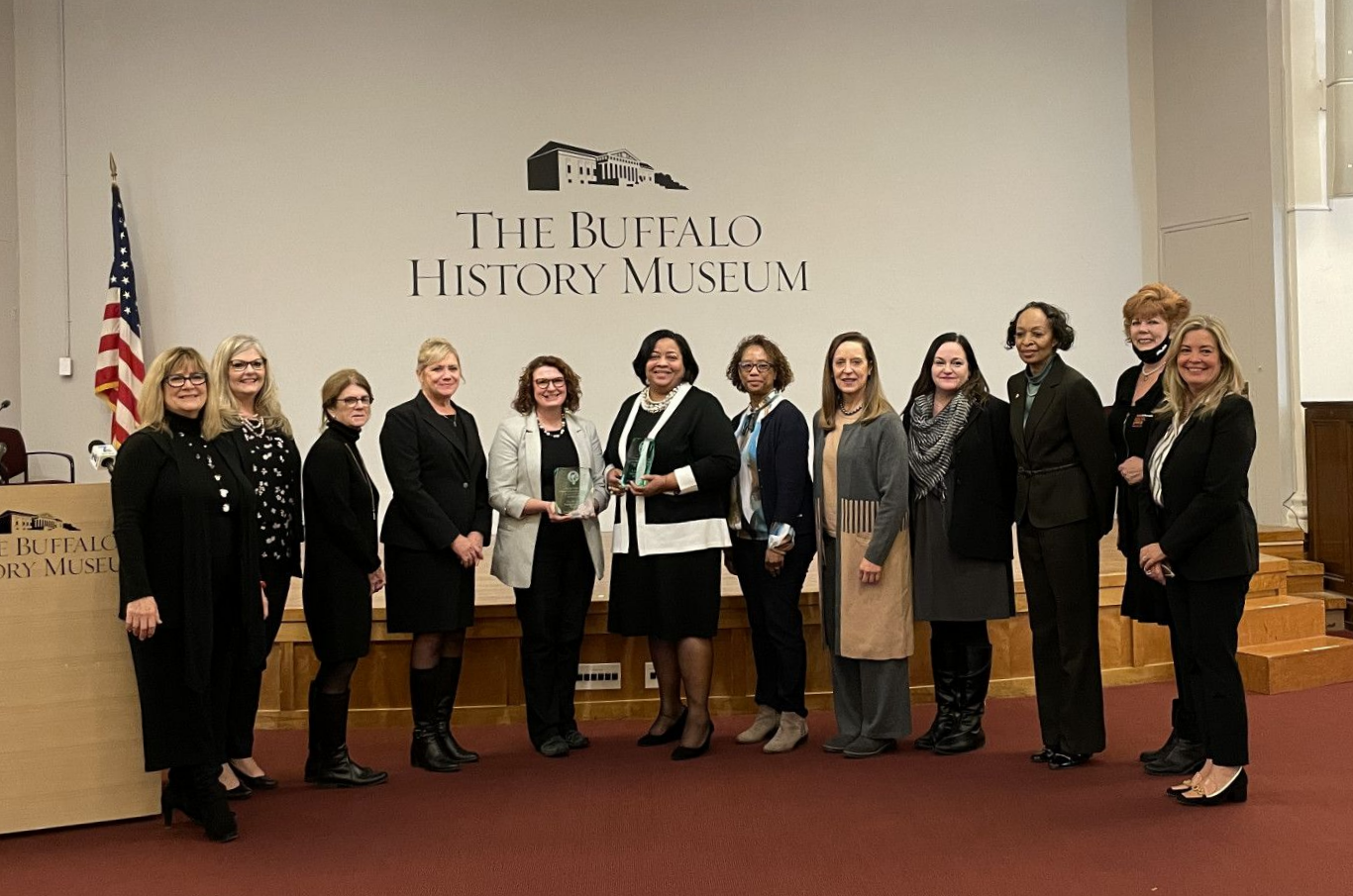 A group of women are posing for a picture in a room.
