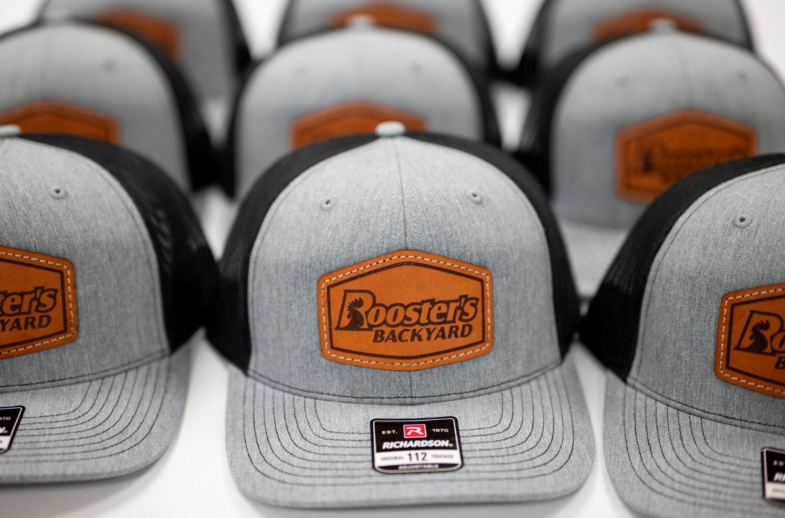 A row of rooster 's backyard hats are lined up on a table
