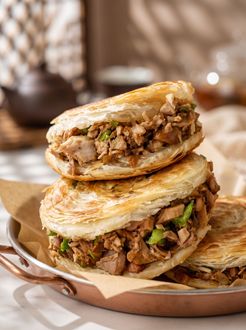 Stacked stuffed flatbreads with spiced meat filling on a plate