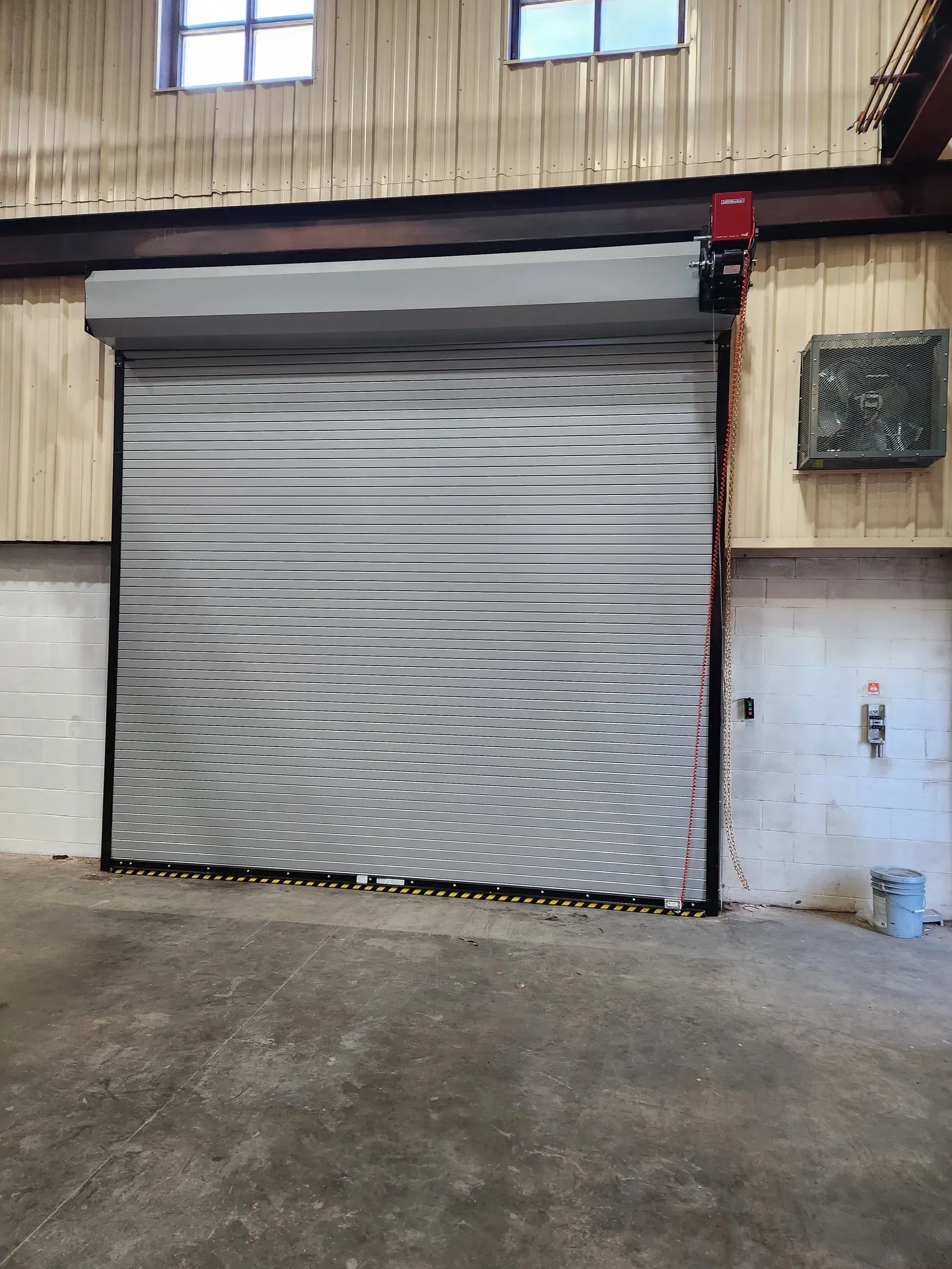 Closed gray roll-up garage door on an industrial building wall
