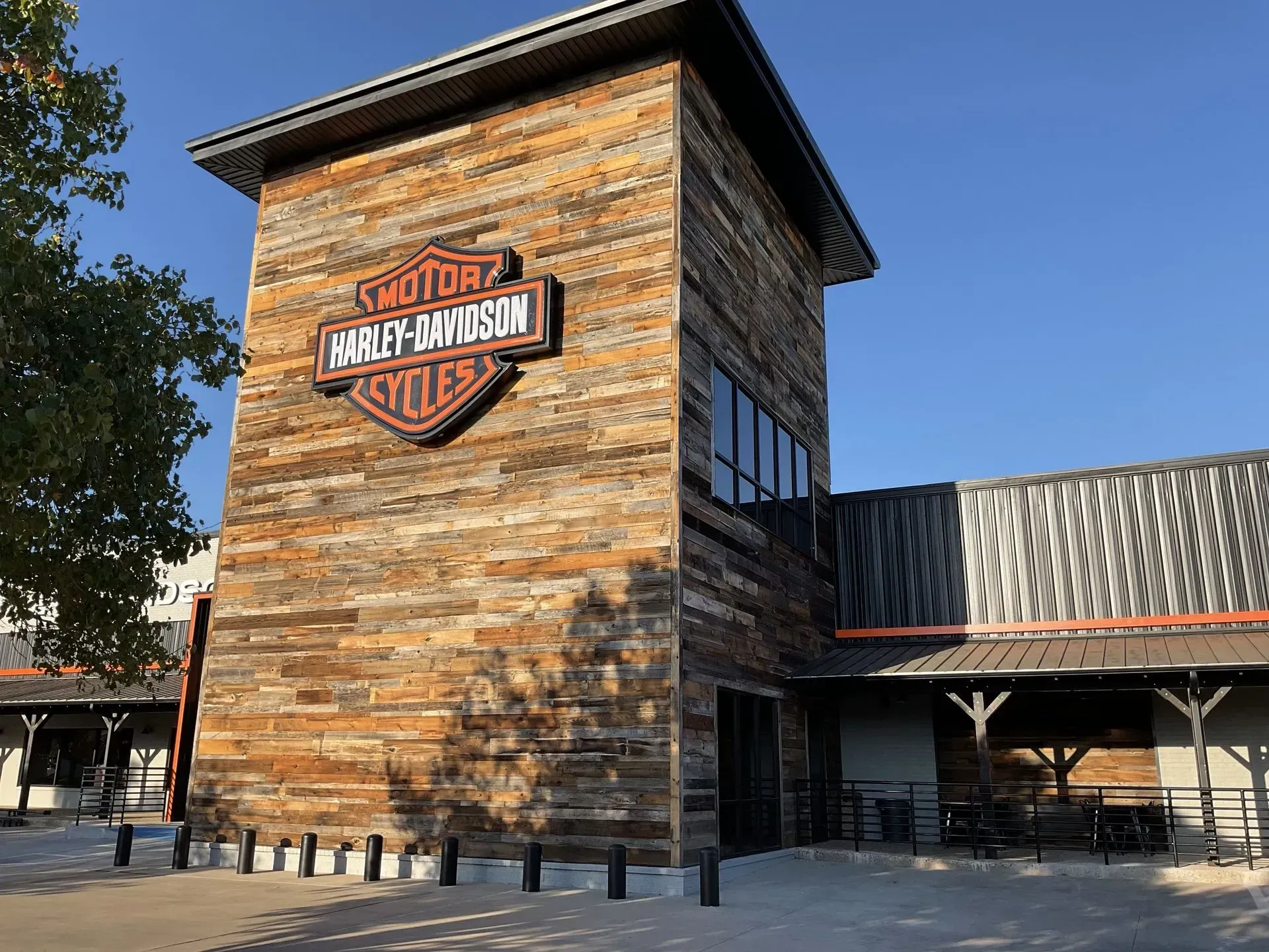 Harley-Davidson building with orange brick facade and large logo under a clear blue sky
