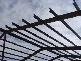 Dark metal beams forming a pergola-like frame against a cloudy sky