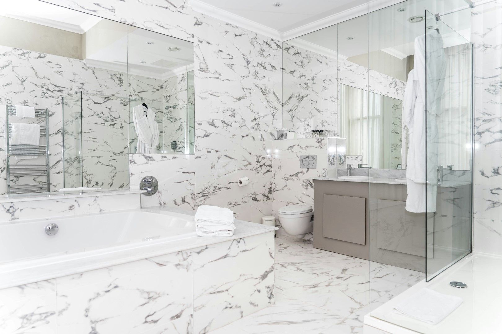 Bright bathroom with white tile walls, glass shower, and clean fixtures after kitchen and bathroom remodeling in Avondale, AZ