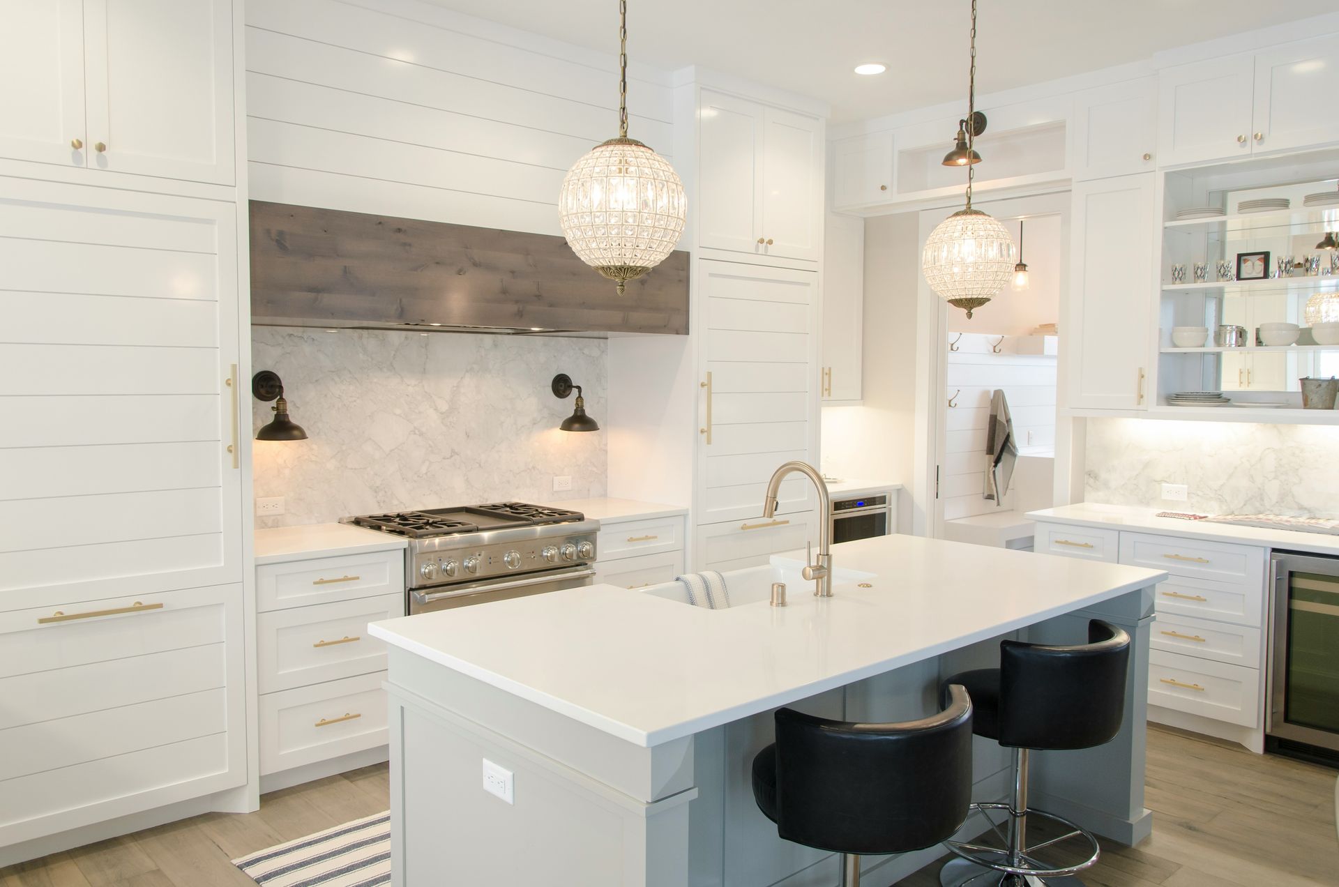 Updated kitchen with white cabinets, island seating, and modern backsplash after kitchen remodeling in Avondale, AZ