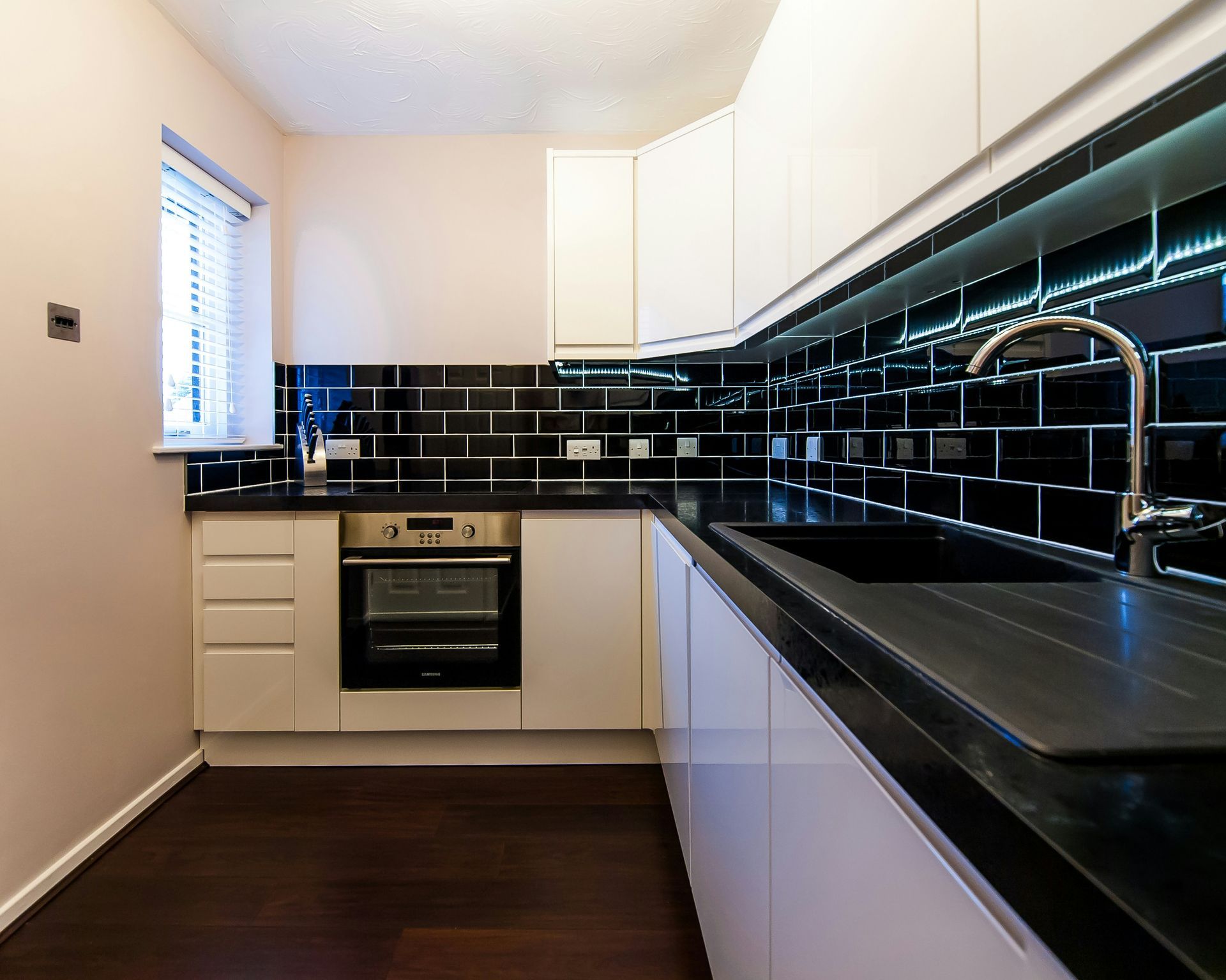 Glossy black kitchen backsplash behind the counter and cabinets during kitchen and bathroom remodeling in Avondale, AZ