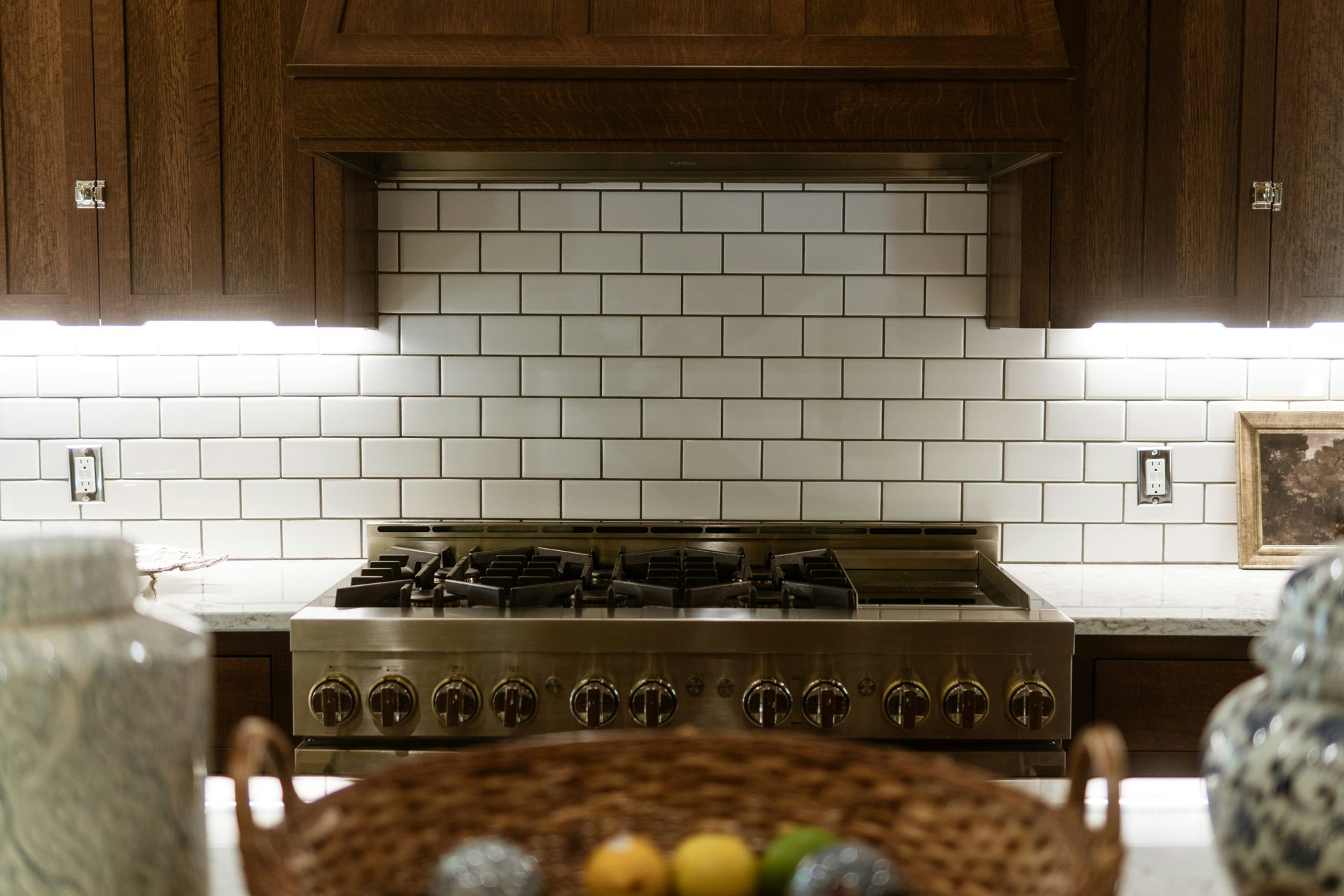 White subway tile backsplash behind a kitchen range and wood cabinets after kitchen and bathroom remodeling in Avondale, AZ