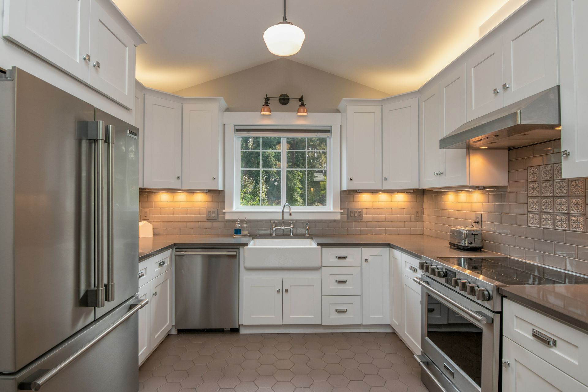 White kitchen with new cabinets, stainless appliances, and tile backsplash after bathroom remodeling in Avondale, AZ