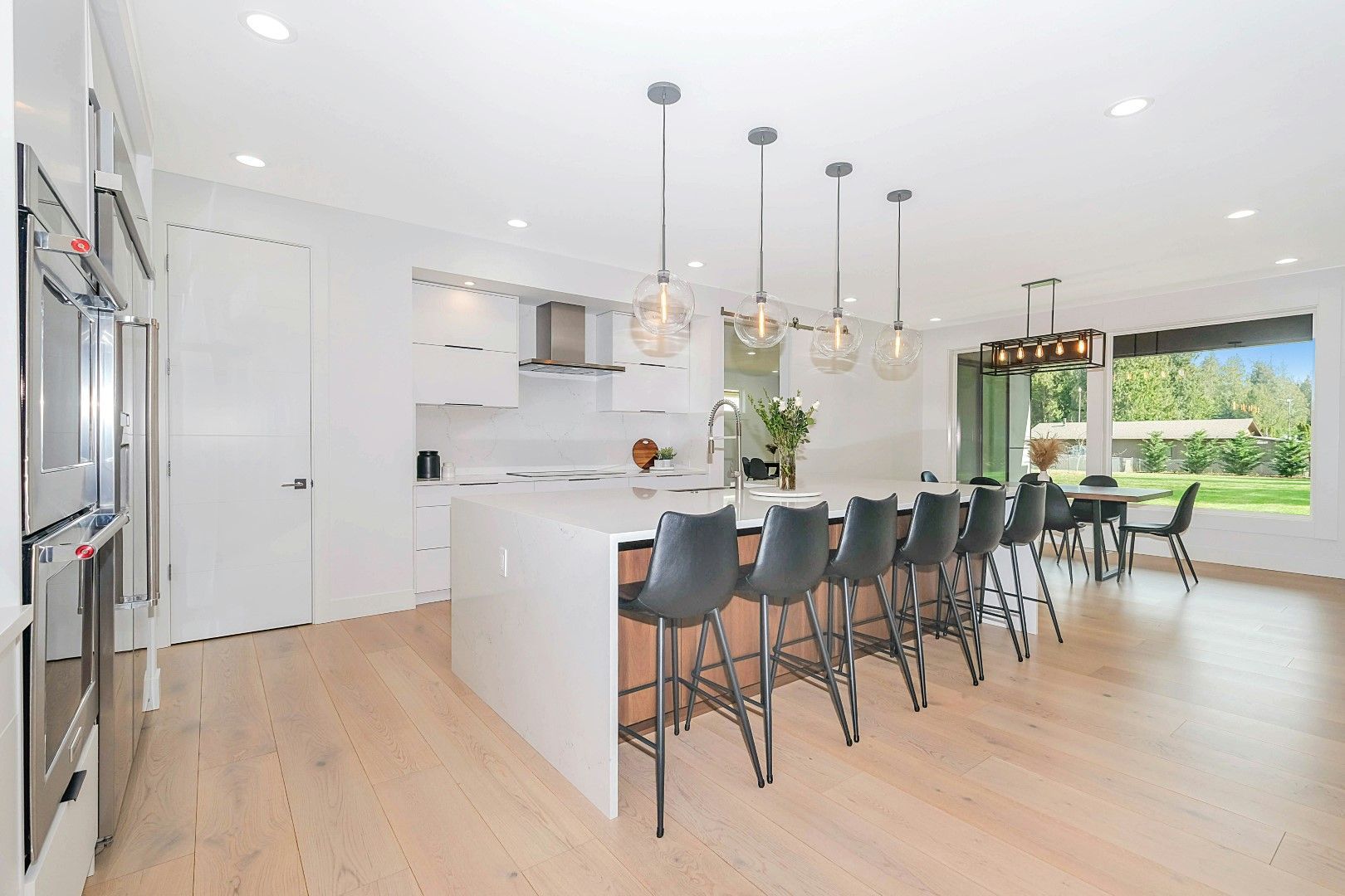 Open white kitchen with island seating, bright lighting, and new flooring from kitchen remodeling in Avondale, AZ