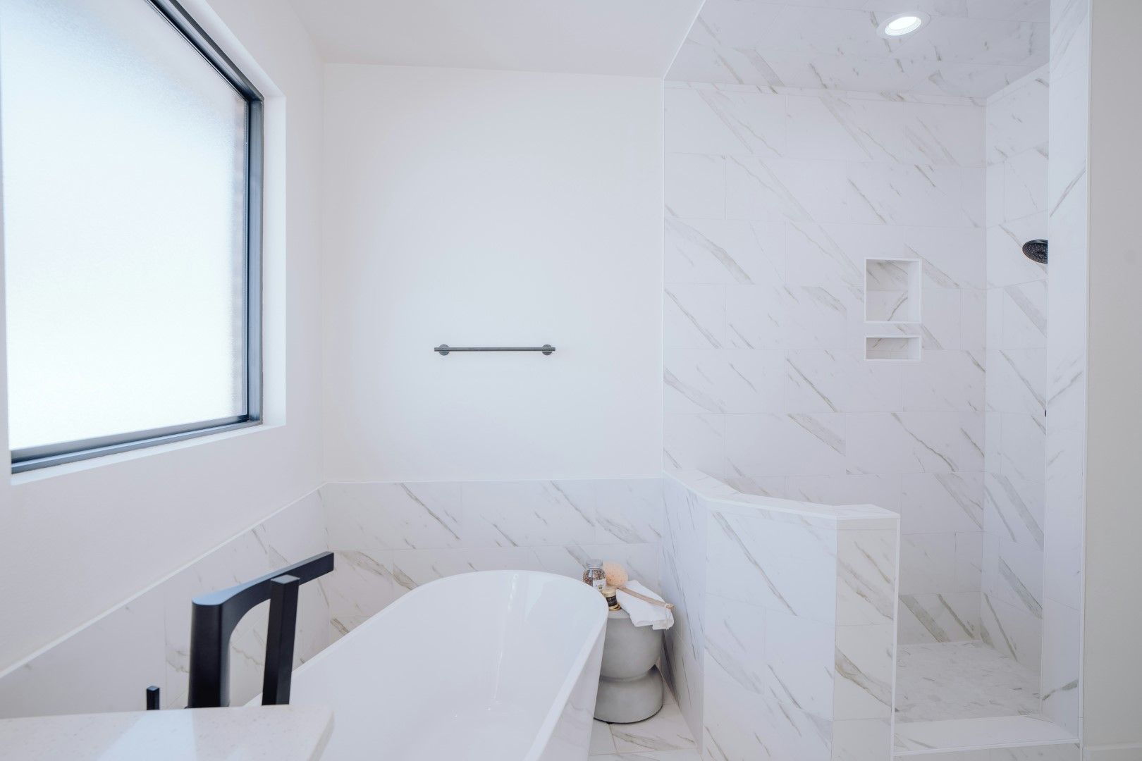 Partially remodeled bathroom with white shower walls and built-in niche during bathroom remodeling in Avondale, AZ