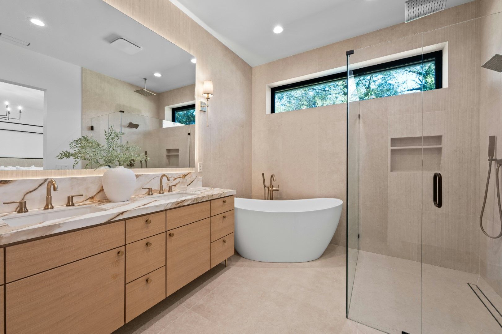 Luxury bathroom with freestanding tub, walk-in shower, wood vanity, and bright tile after bathroom remodeling in Avondale, AZ
