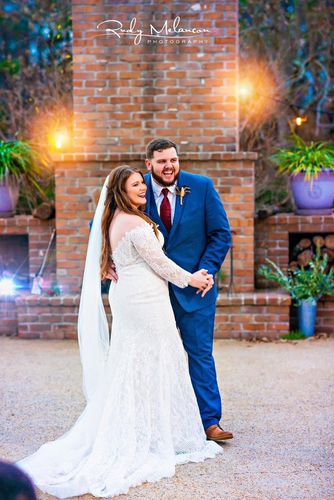 smiling bride and groom in front of fireplace