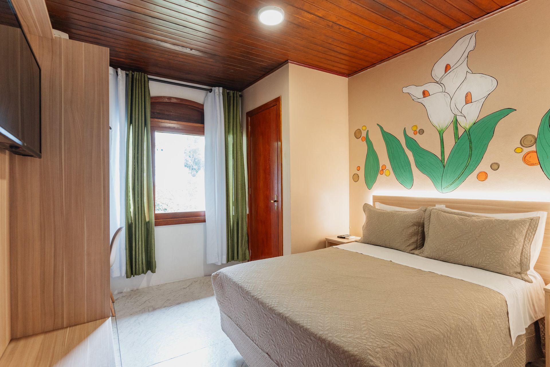 Um quarto de hotel com uma cama e uma pintura na parede.- Pousada Santo Antônio