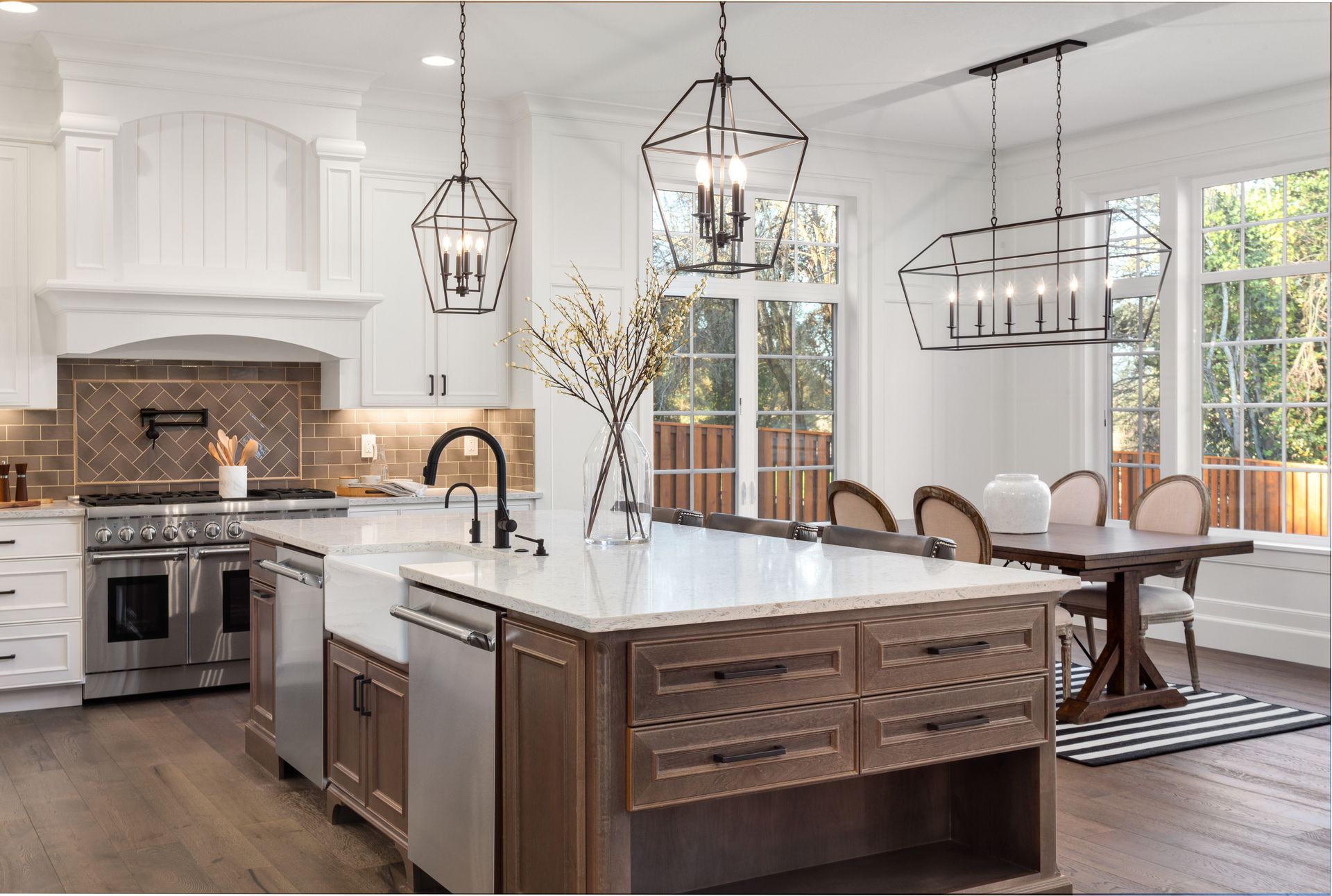 Elegant kitchen with a large island, stainless steel appliances, and pendant lights.