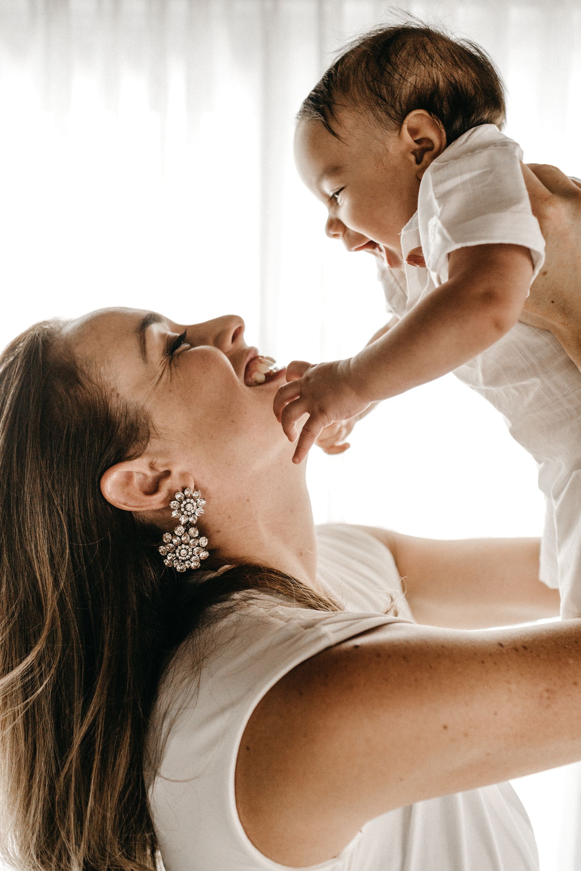 a mother is holding her baby up in the air .