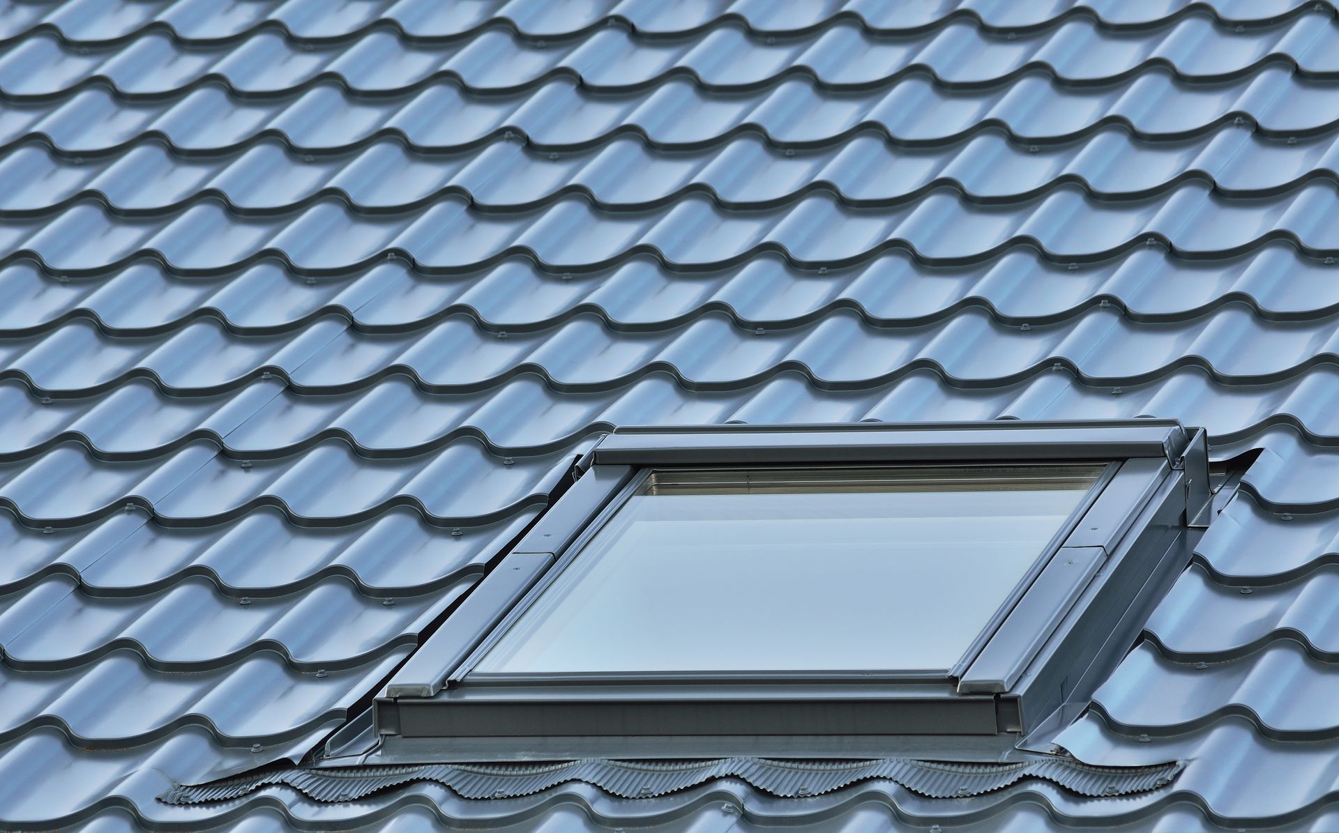 Blue-gray roof with a skylight window set into the shingles