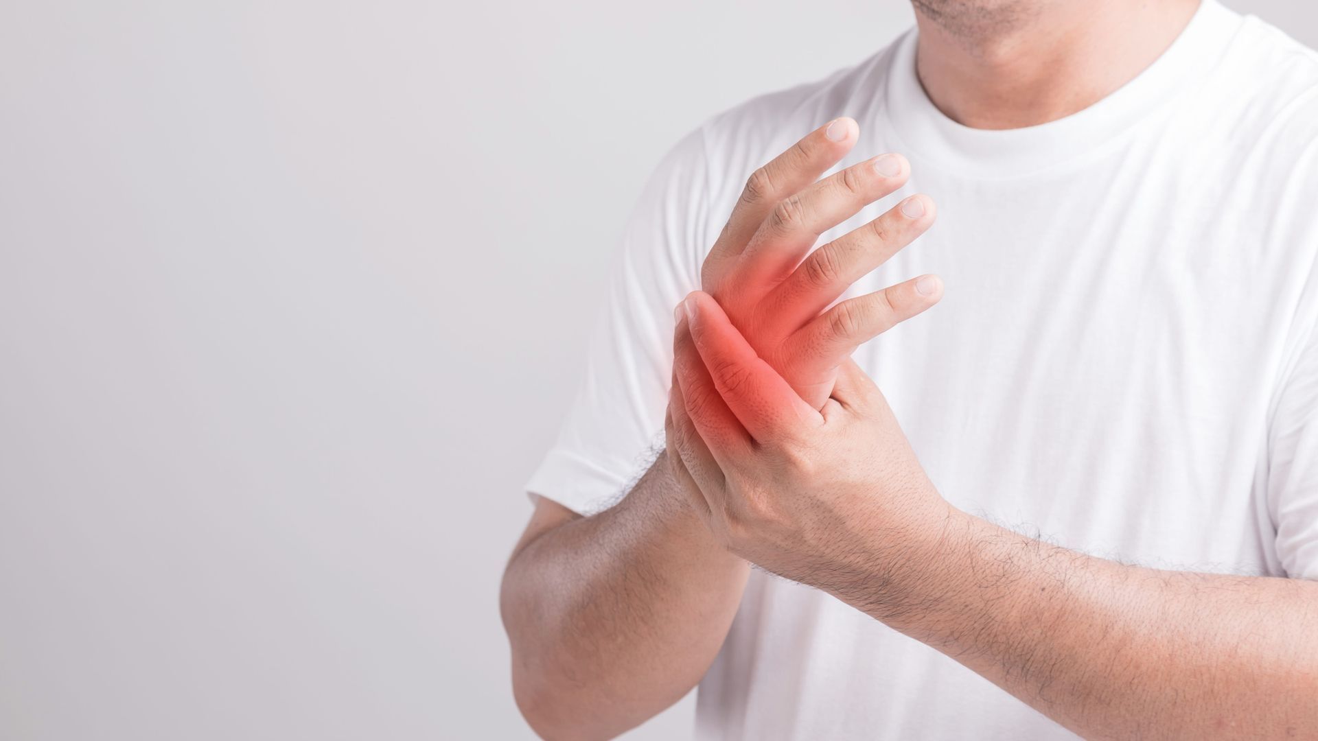 A person holding a painful red wrist with both hands