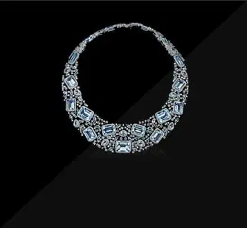 Silver and blue jeweled necklace on a black background