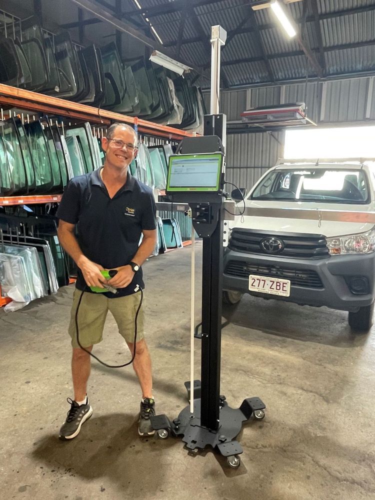 Man in Shop Poses With a Tall Diagnostic Tool — O'Brien Carglass & Tinting in Mareeba, QLD