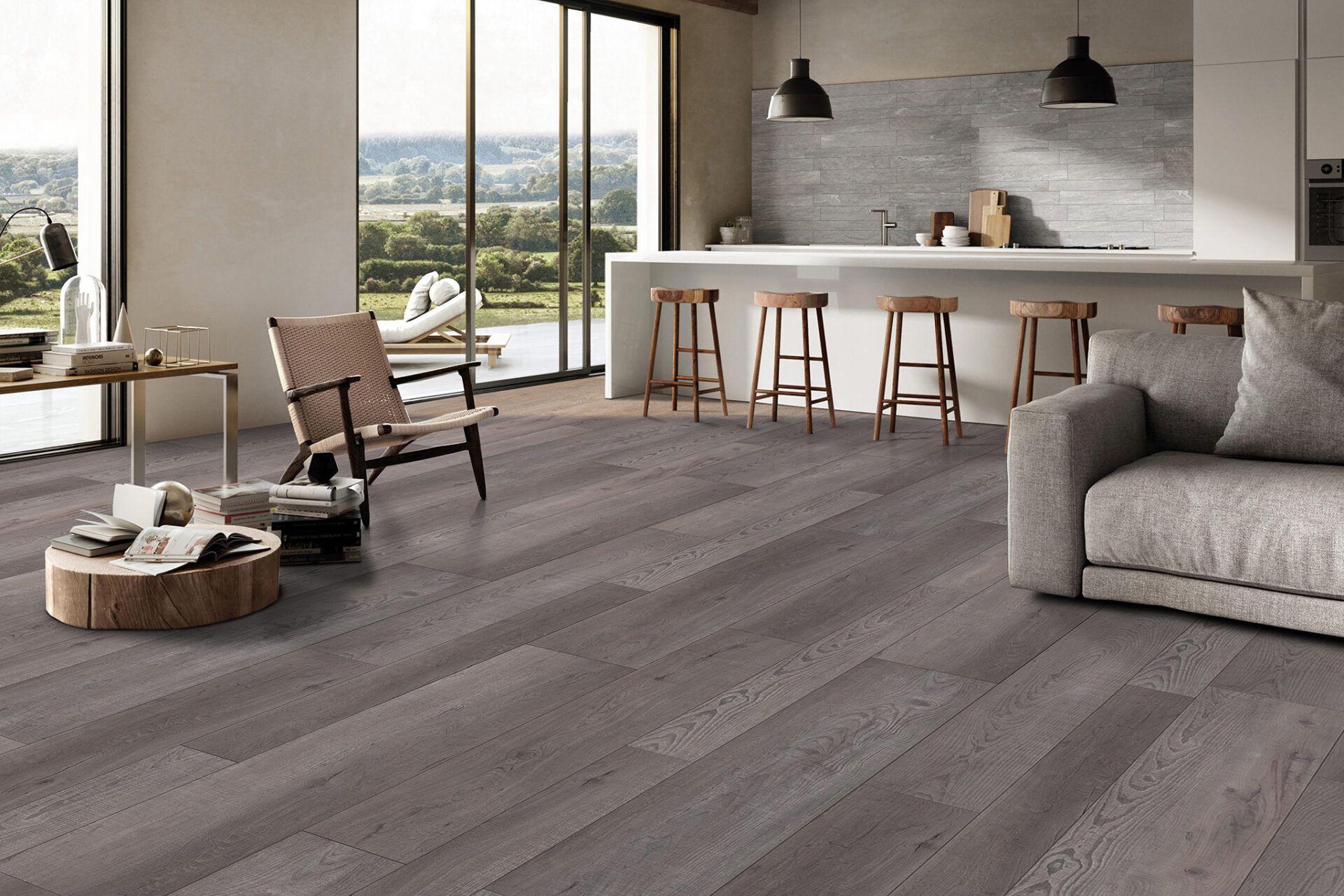 Modern living room with gray flooring, kitchen island, and view of landscape.