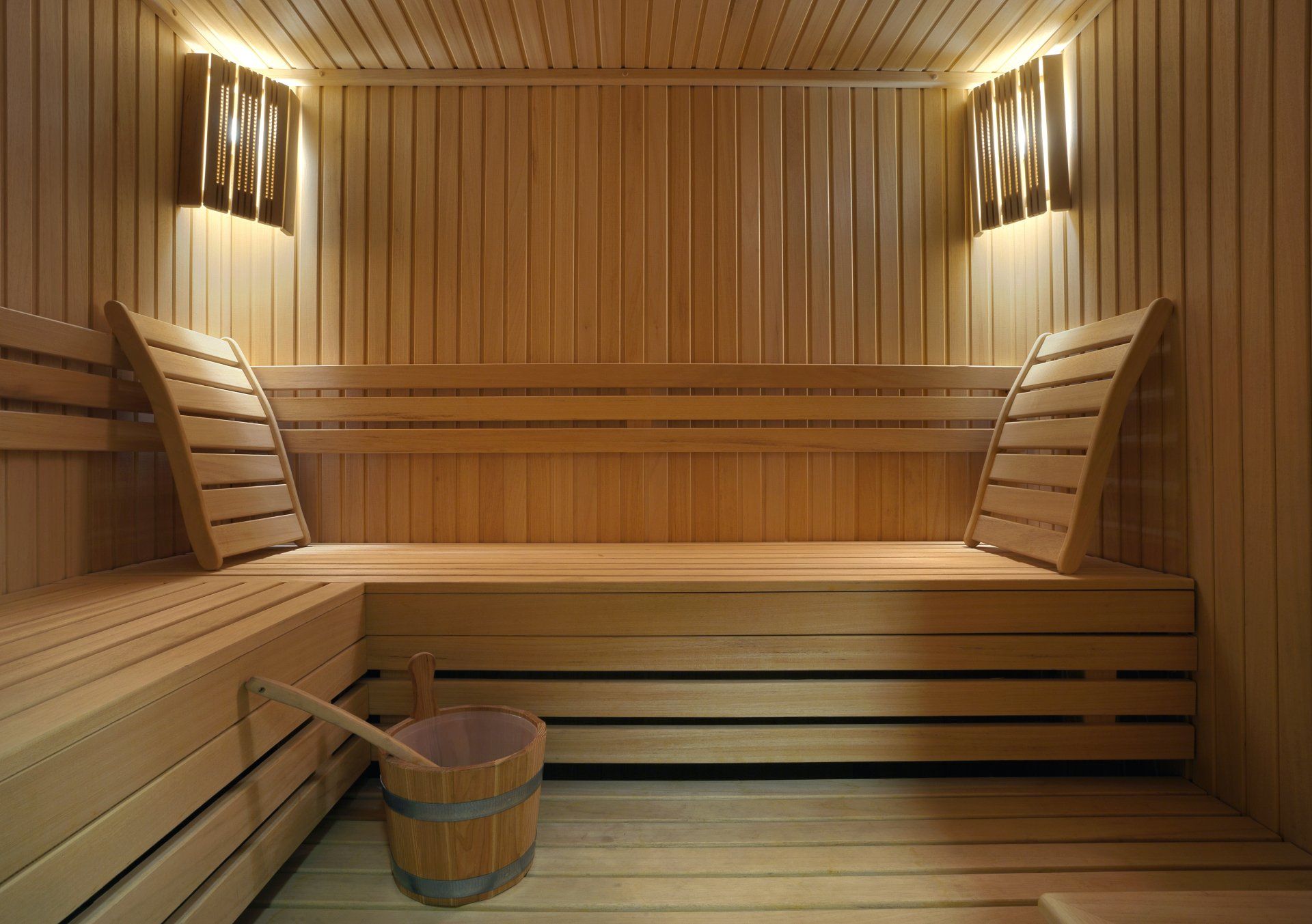 Steam room showing the wooden benches, back rests and wooden light fixtures for soft lighting