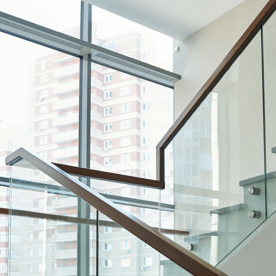 Staircase with glassed in railing and view out the picture window