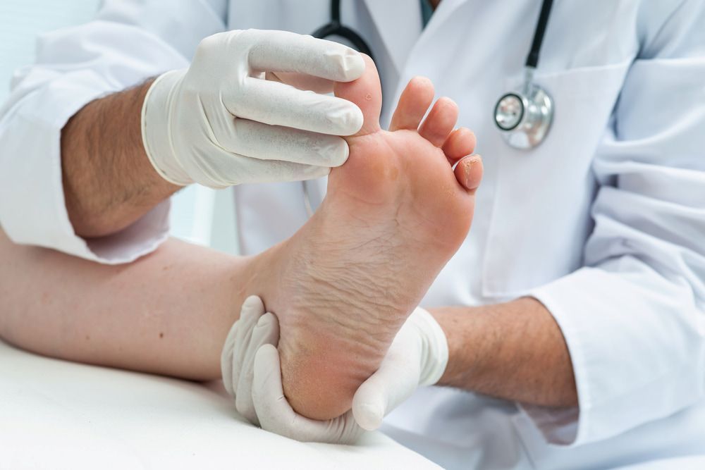 A Doctor Is Examining A Patient's Foot — Lake Macquarie Podiatry in Belmont, NSW