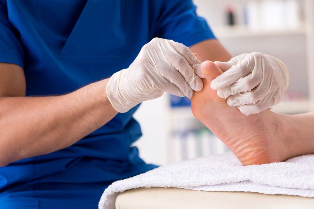 A Doctor Is Examining A Patient's Foot In A Hospital — Lake Macquarie Podiatry in Rathmines, NSW