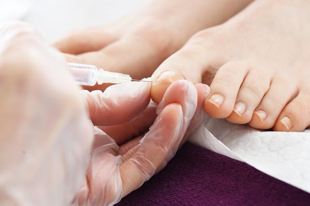 A Woman Is Getting Her Toenails Painted By A Nail Artist — Lake Macquarie Podiatry in Swansea, NSW