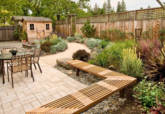 back yard with wooden fence and stone paths landscaping
