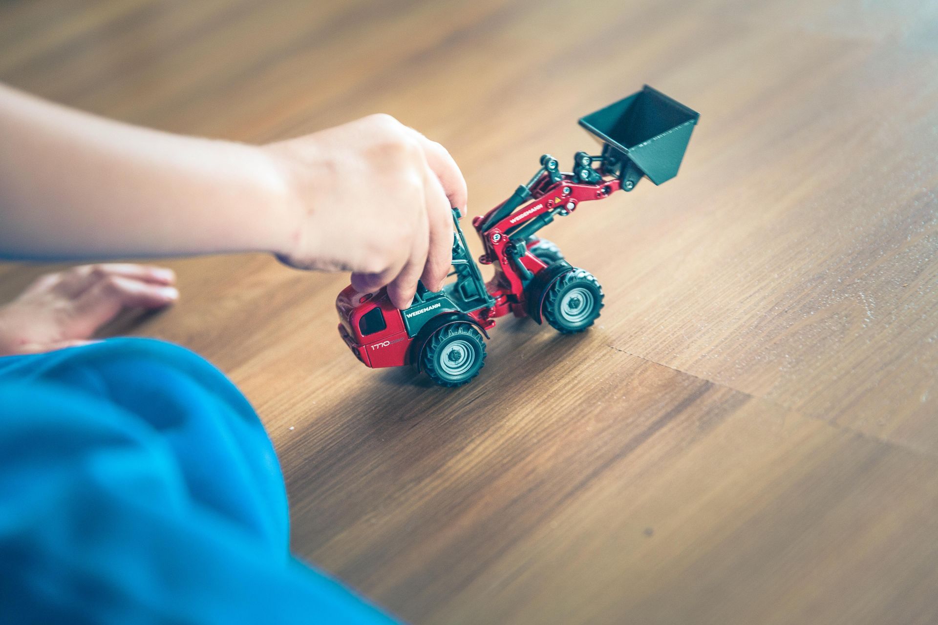 Boy playing with a mini-excavator toy, symbolizing compact construction equipment power for tight job sites in Hawaii