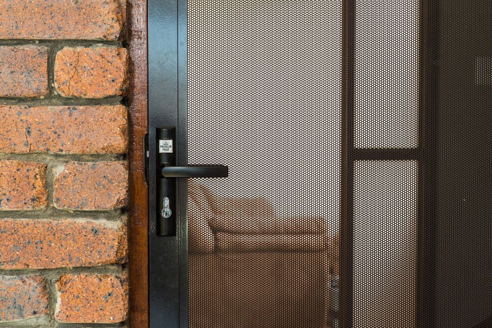 Exterior of a White House With a Decorative Security Door — All Security Screens & Repairs In Bungalow, QLD