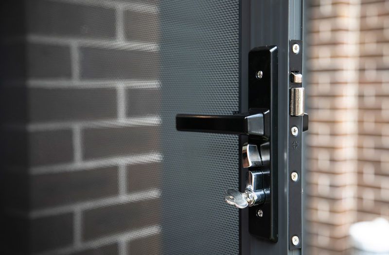 White Door With a Silver Handle, Key, and Security Lock — All Security Screens & Repairs In Bungalow, QLD
