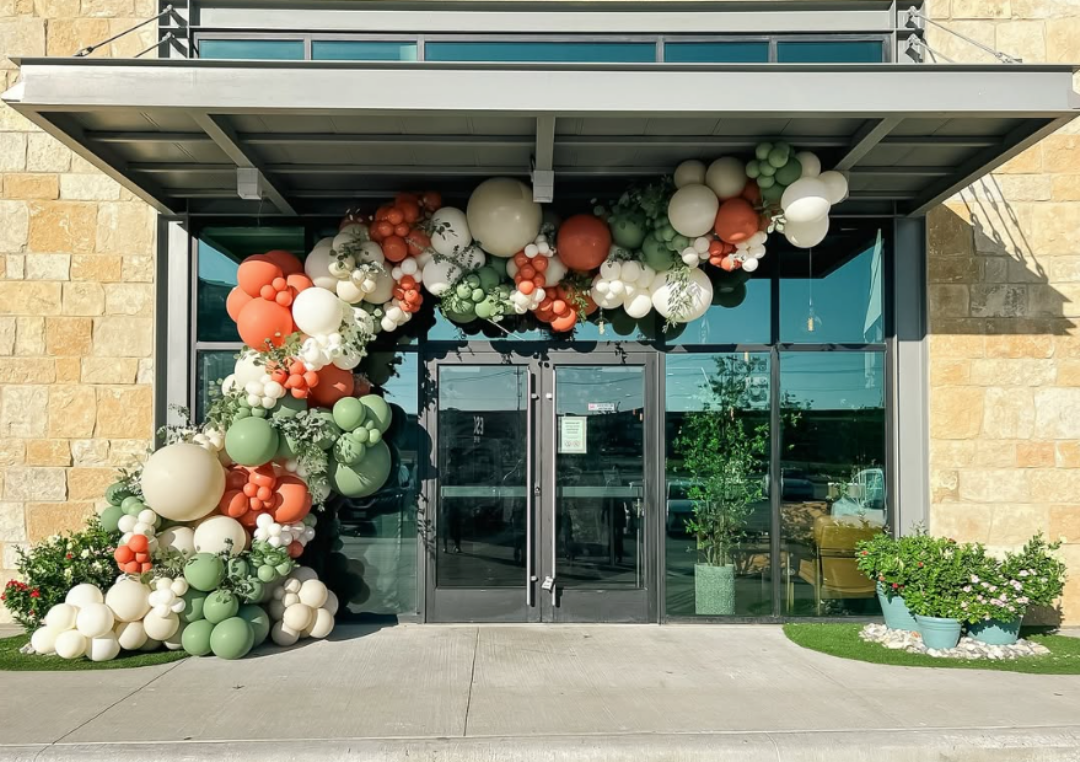 Organic fall balloon garland installation at a Central Florida event entrance
