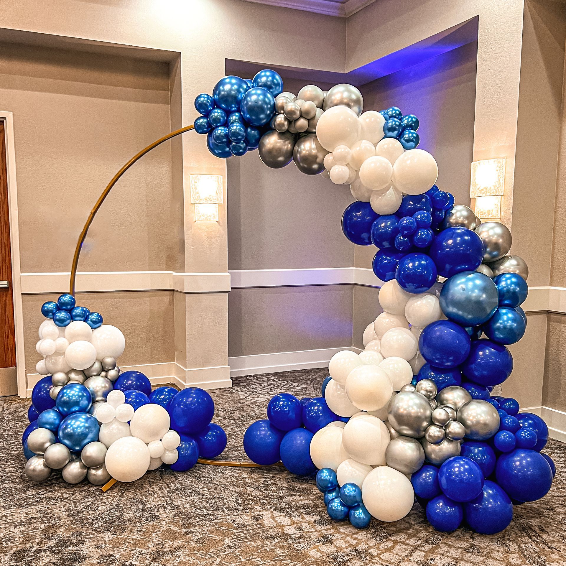A room filled with blue , white , and silver balloons.