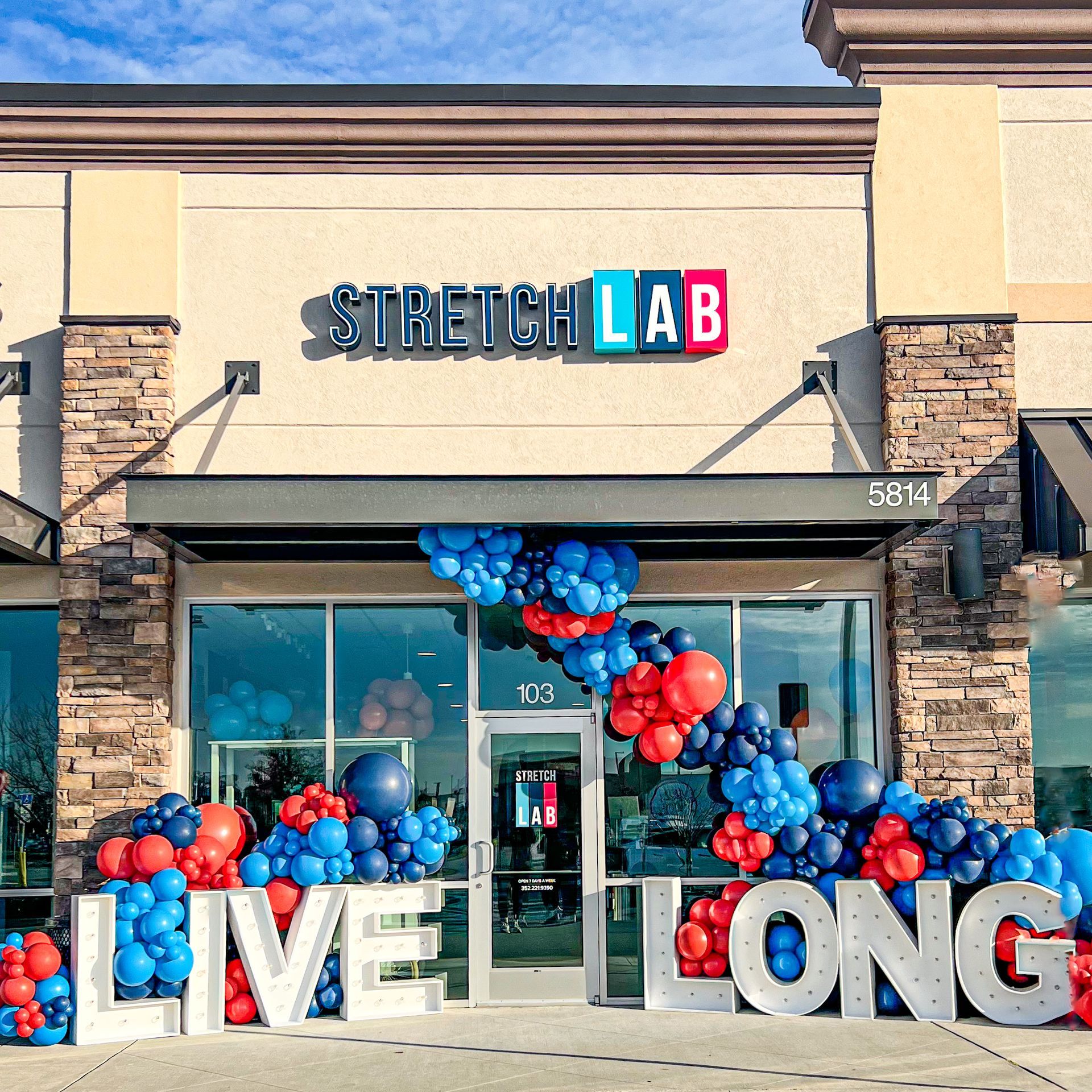 Stretch Lab storefront with blue and red balloon arch and