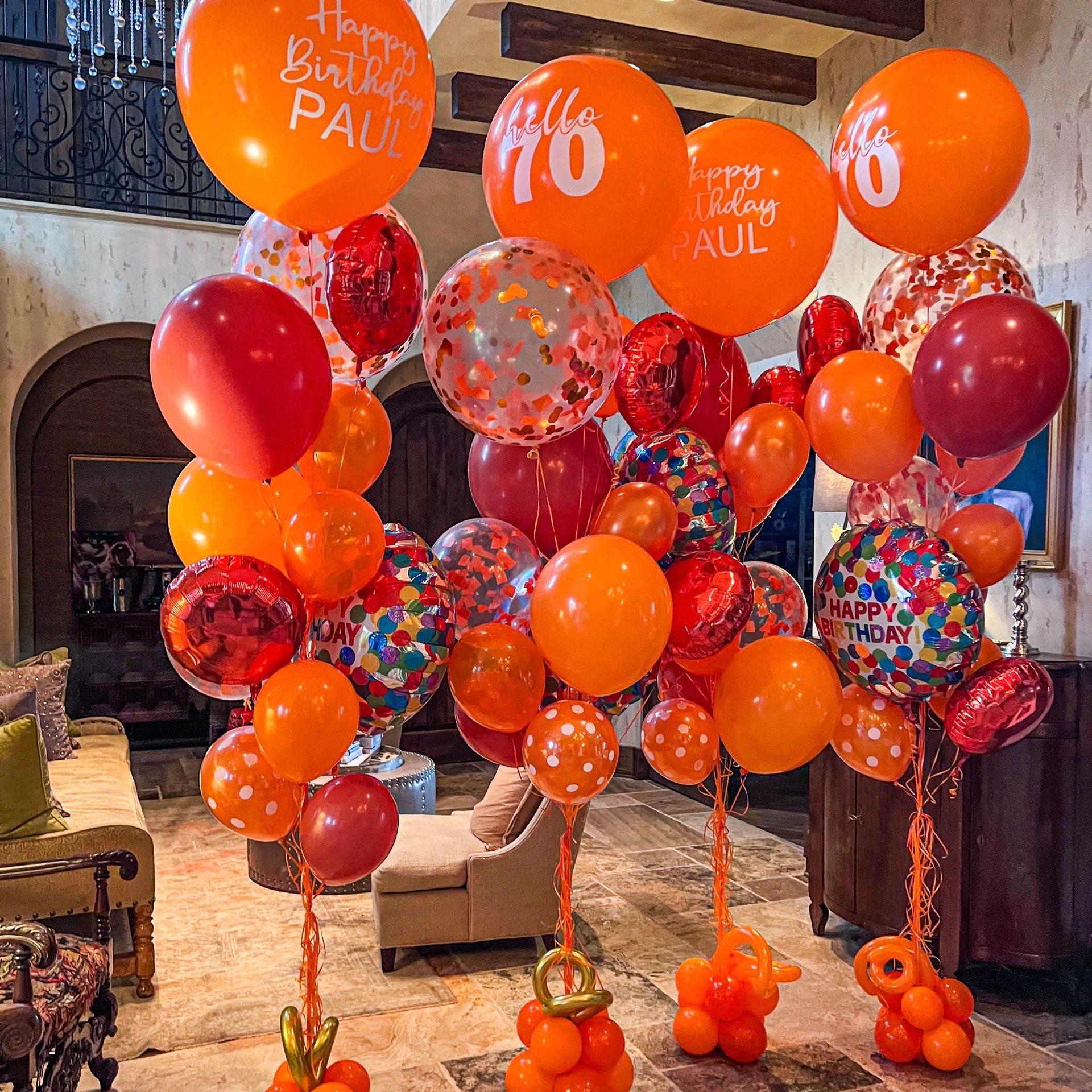 A bunch of orange balloons with the number 70 on them