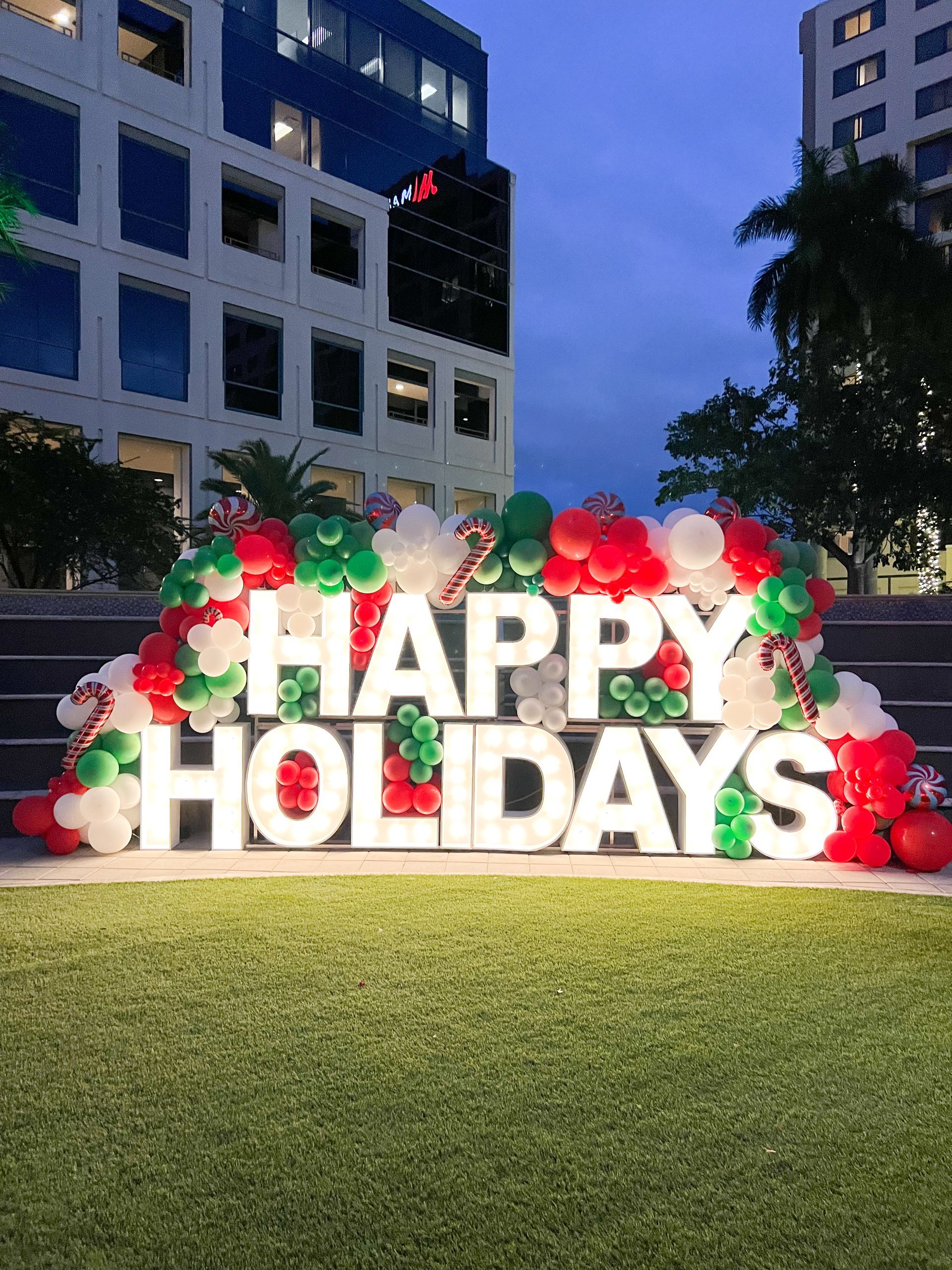 A happy holidays balloon decor setup using marquee letters