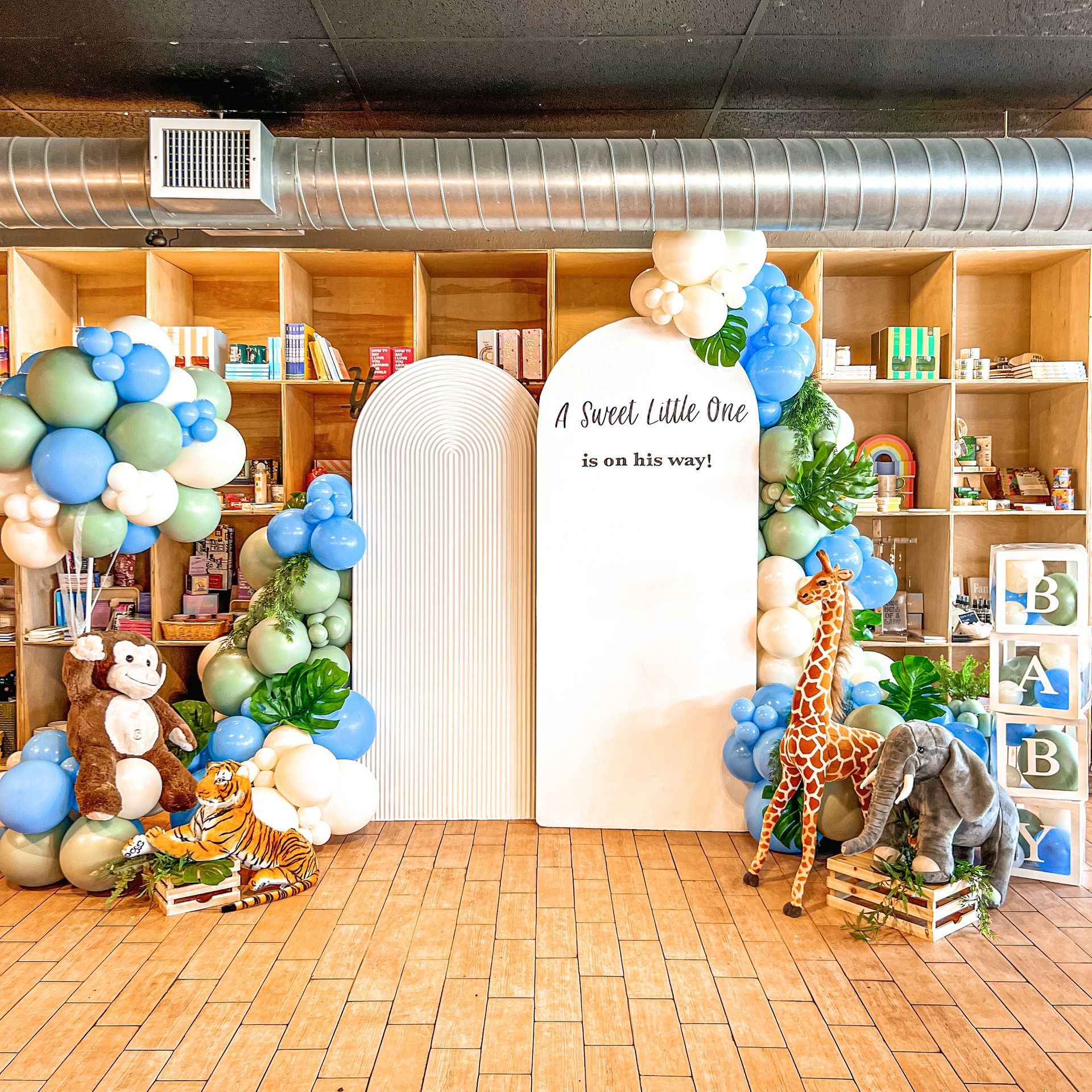 A room with balloons and stuffed animals and a sign that says a sweet little one