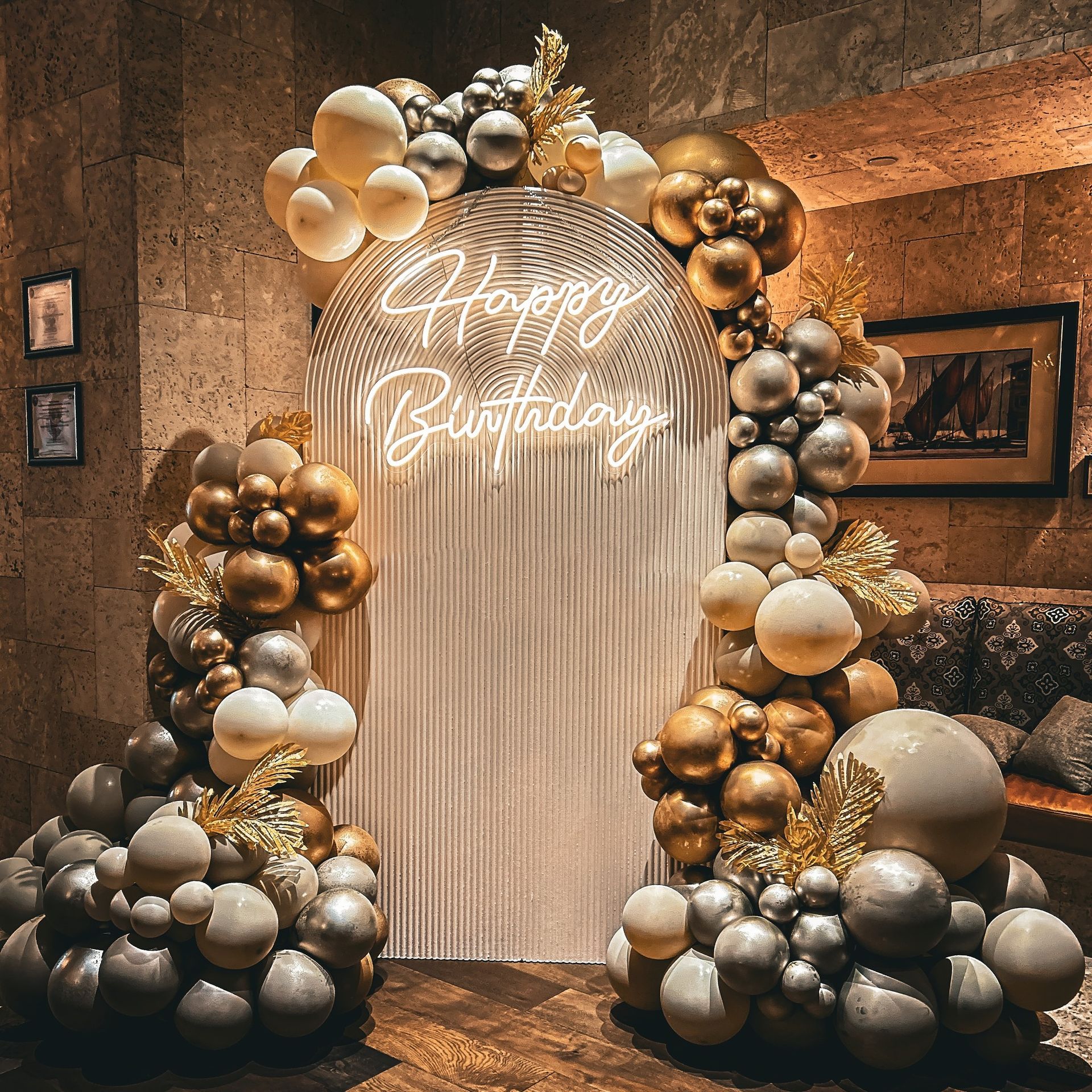A room filled with balloons and a neon sign that says `` happy birthday ''.