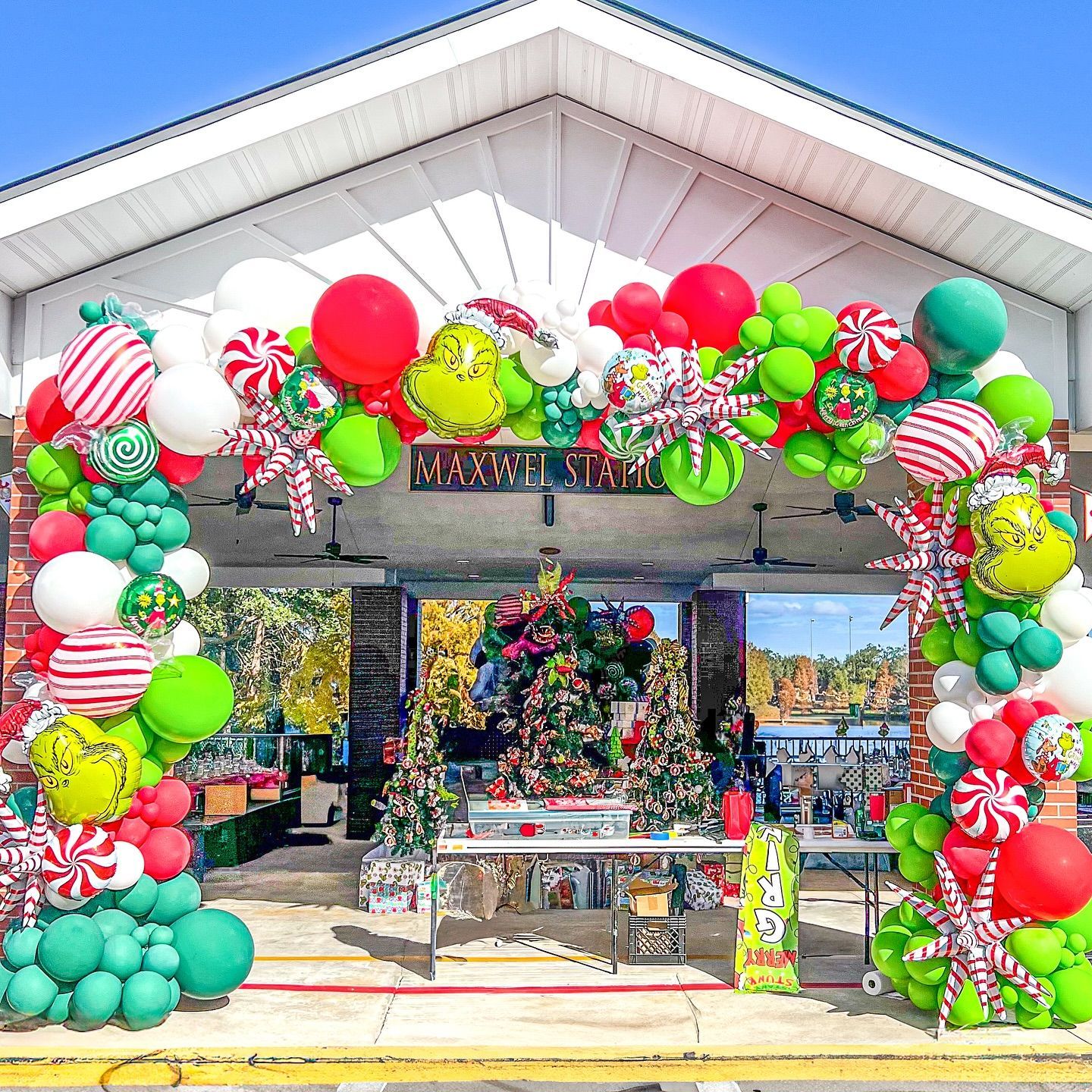 An outdoor christmas themed balloon arch with various colored balloons