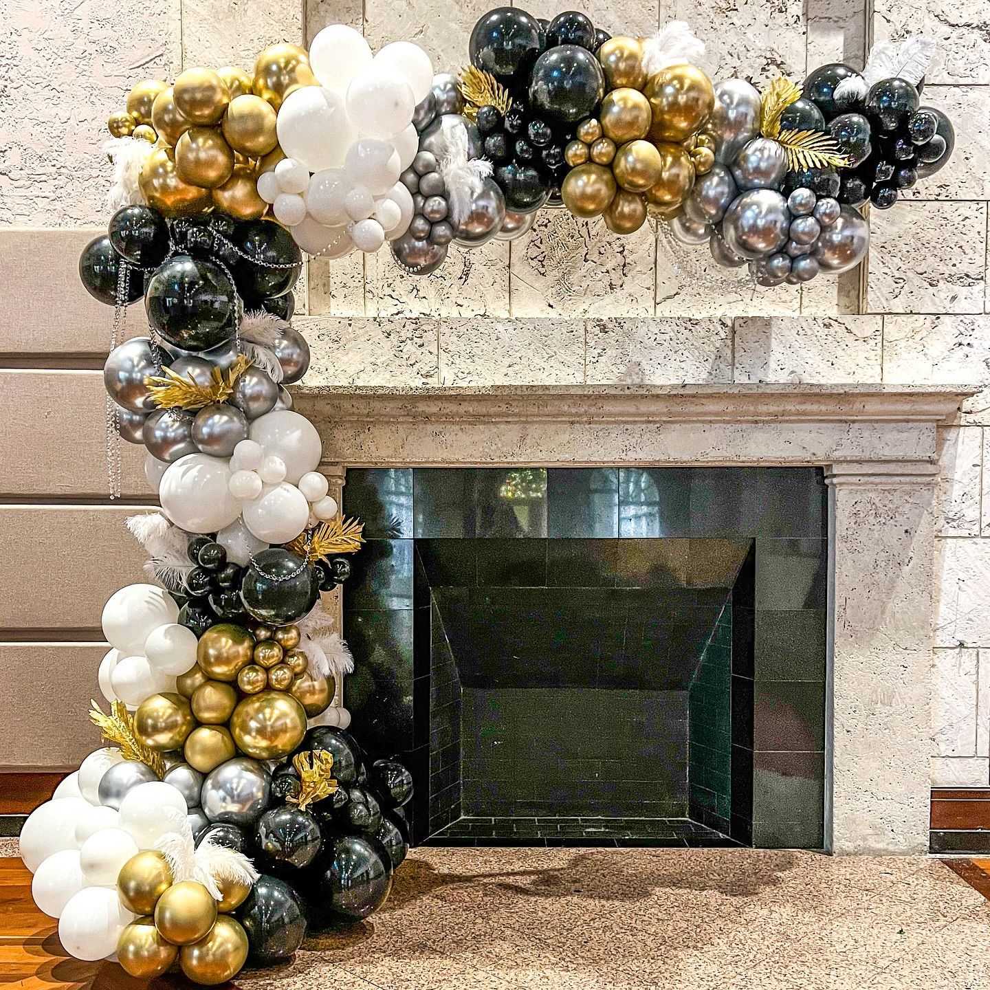 a large g is surrounded by balloons and confetti .